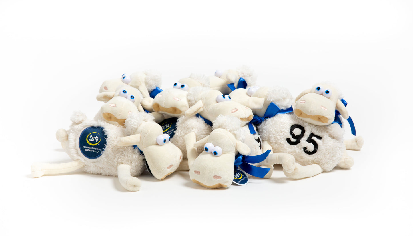 Stack of white Seta plush sheep toys with blue ribbons and a number 95 on a white background