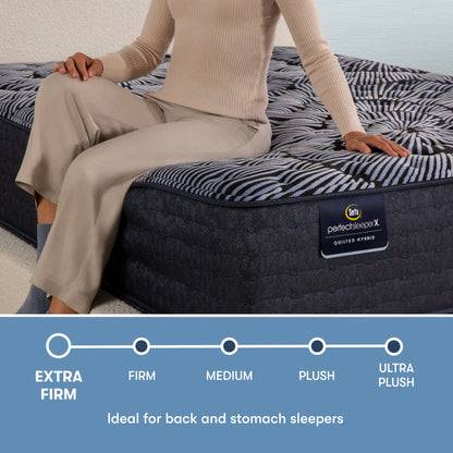 Perfect Sleeper X Quilted Hybrid Excelled Extra Firm comfort scale with a woman sitting on the left side of the mattress || feel: Extra Firm || level: Level 1