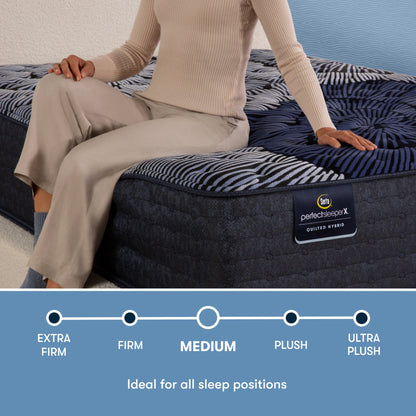 Perfect Sleeper X Quilted Hybrid Max Medium comfort scale with a woman sitting on the left side of the mattress || feel: Medium || level: Level 2